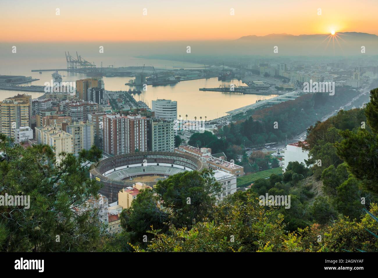 Vista panoramica di Malaga al tramonto sulla Costa del Sol spagnola con vista panoramica della città, il porto, le case, gli alberi, la corrida Foto Stock