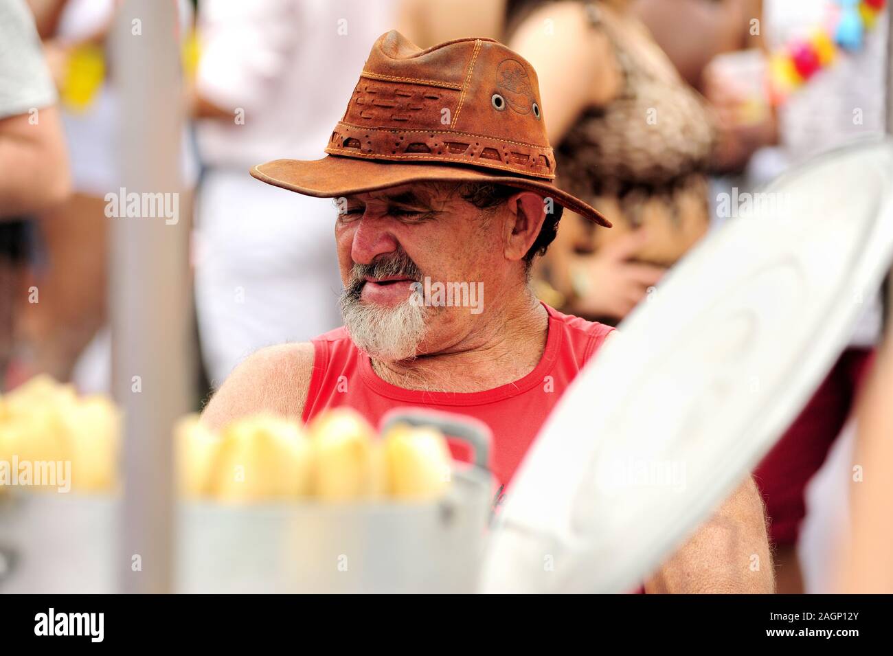 Sud America, Brasile - 3 marzo 2019: Uomo che vende mais bollito durante una sfilata di strada di carnevale che si tiene nel centro di Rio de Janeiro. Foto Stock