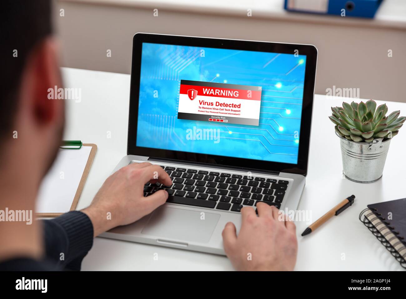 Virus rilevato il messaggio di avviso sullo schermo del computer, cyber attacco concetto. Uomo al lavoro su un notebook, office business scrivania di legno dello sfondo. Foto Stock