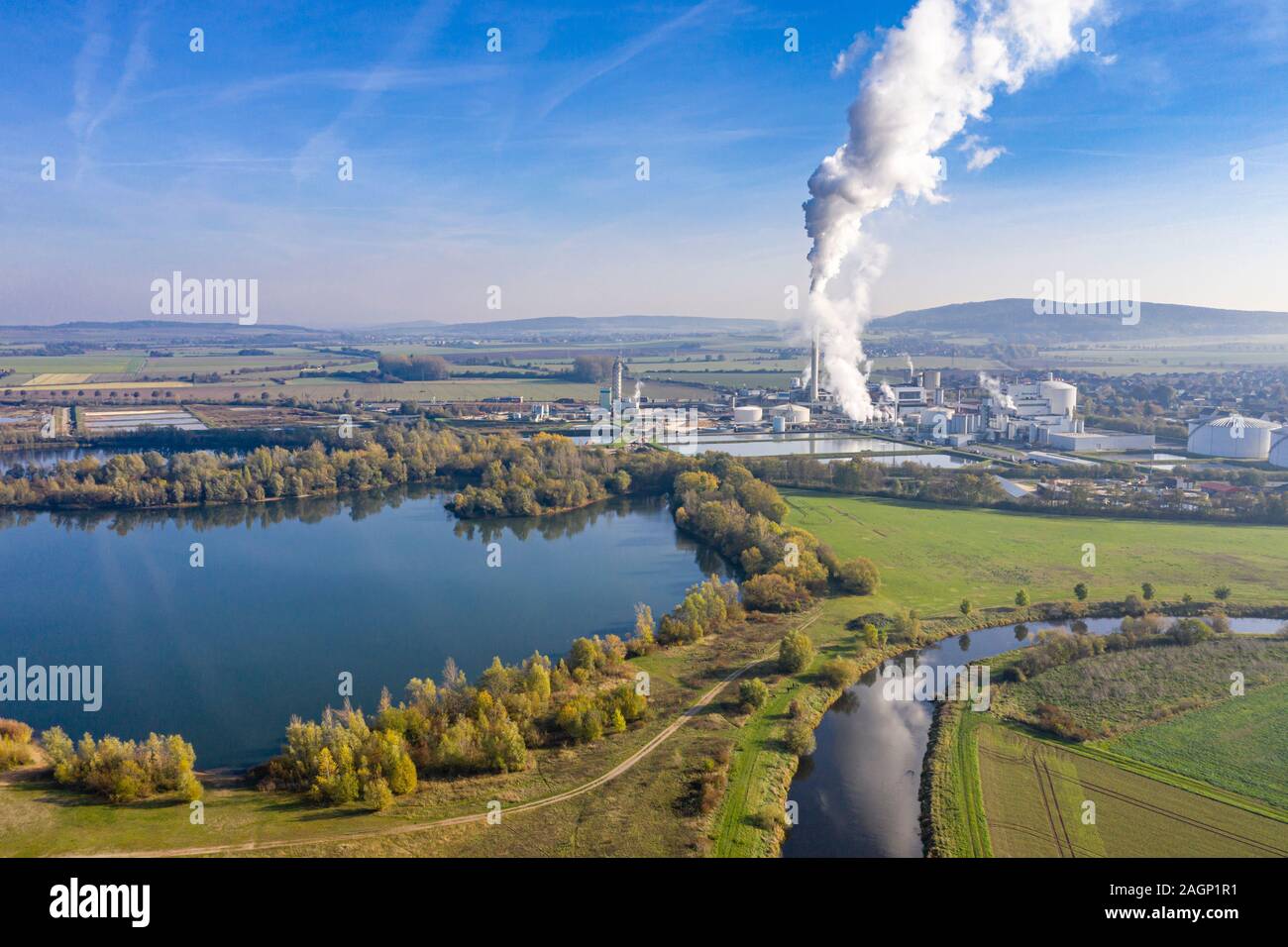 Drone shot del fiume Leine con Nordzucker fabbrica di zucchero in Nordstemmen, comignoli fumanti in una fredda giornata soleggiata, Germania Foto Stock