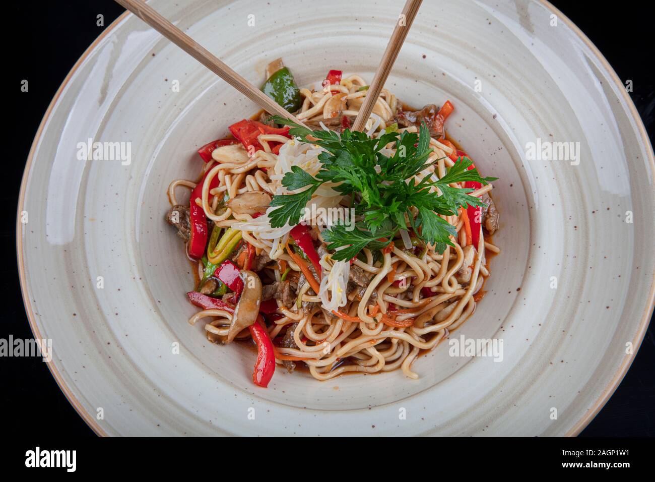 Pad Thai vegetariana verdure udon tagliatelle in uno sfondo scuro, vista dall'alto. Cibo vegetariano in stile asiatico. Spazio di copia Foto Stock