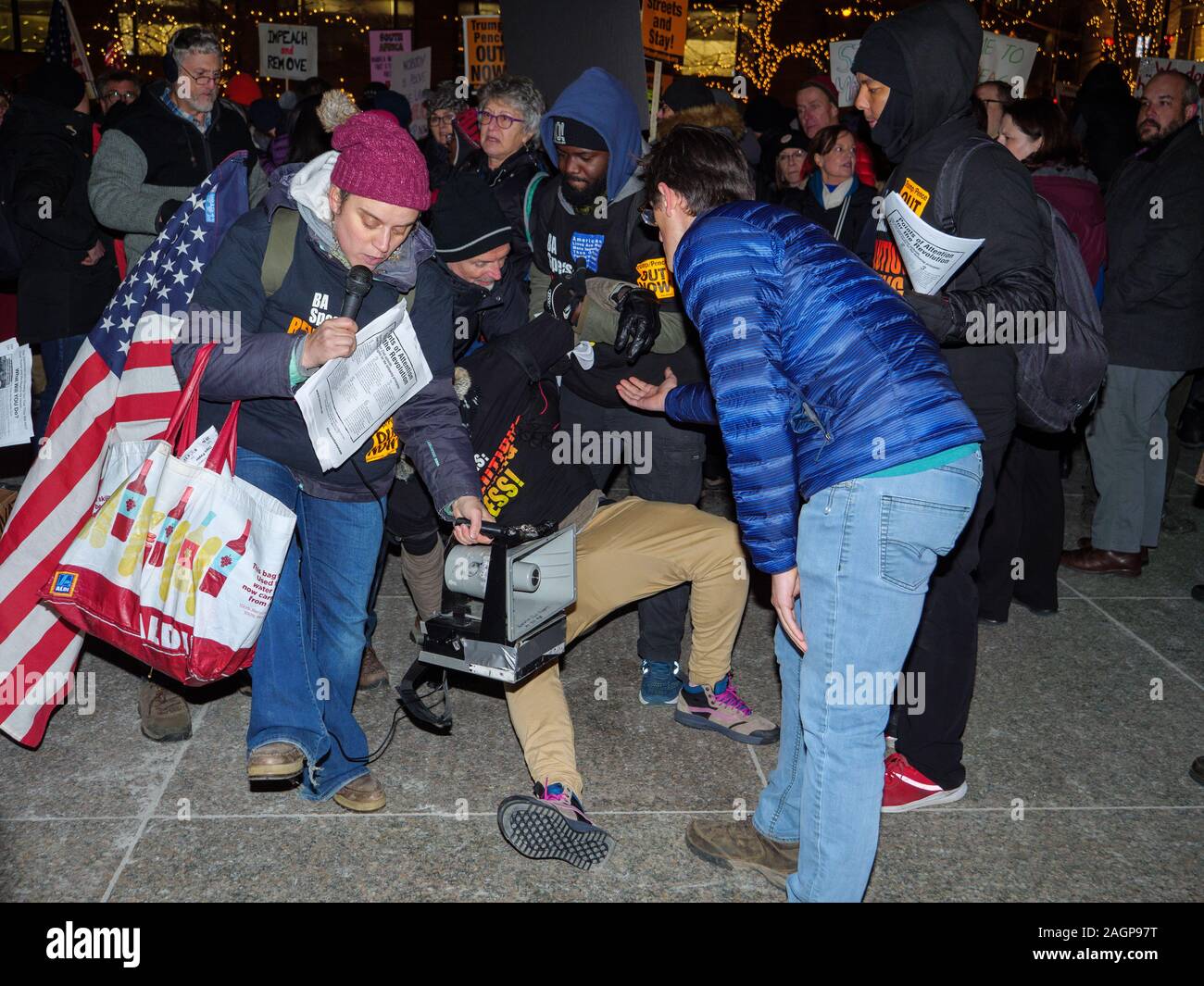 Chicago, Illinois, Stati Uniti d'America. 17 dicembre 2019. I dimostranti nel rally Federa Plaza, quindi marzo al Trump Tower esigente impeachment del Presidente Trump. Un membro del Partito Comunista è aiutato fino dopo essere stato spinto a terra da un altro manifestante in Federal Plaza. Foto Stock