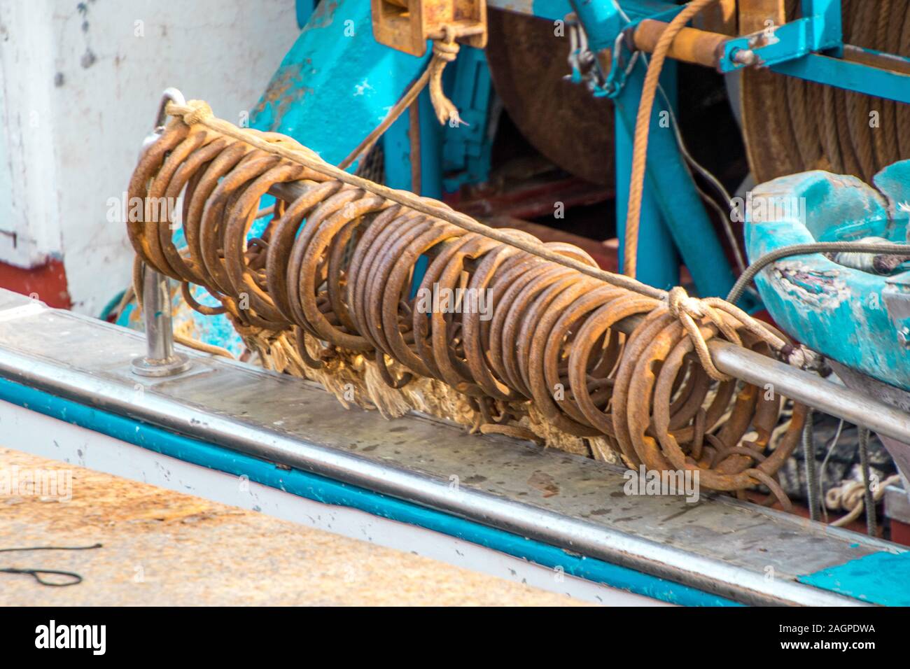 Anelli di acciaio sul lato di una piccola barca da pesca nel porto di Catania, in Sicilia, Italia. Foto Stock