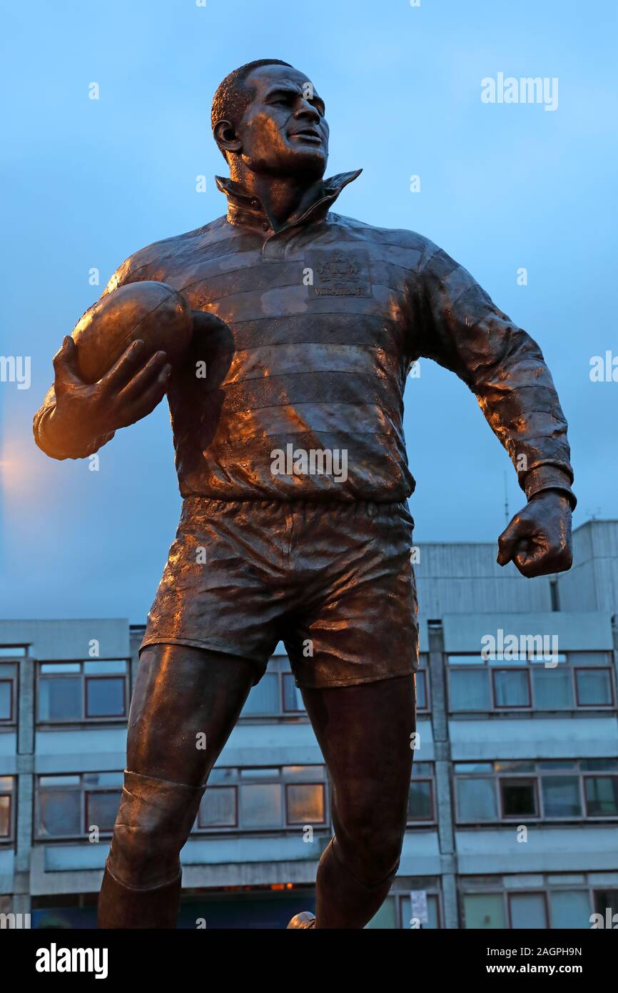 Billy Boston statua MBE , Il Wiend, Wigan Town Center, Greater Manchester, Inghilterra, Regno Unito, WN1 1YB al tramonto ( William John Boston ) Foto Stock