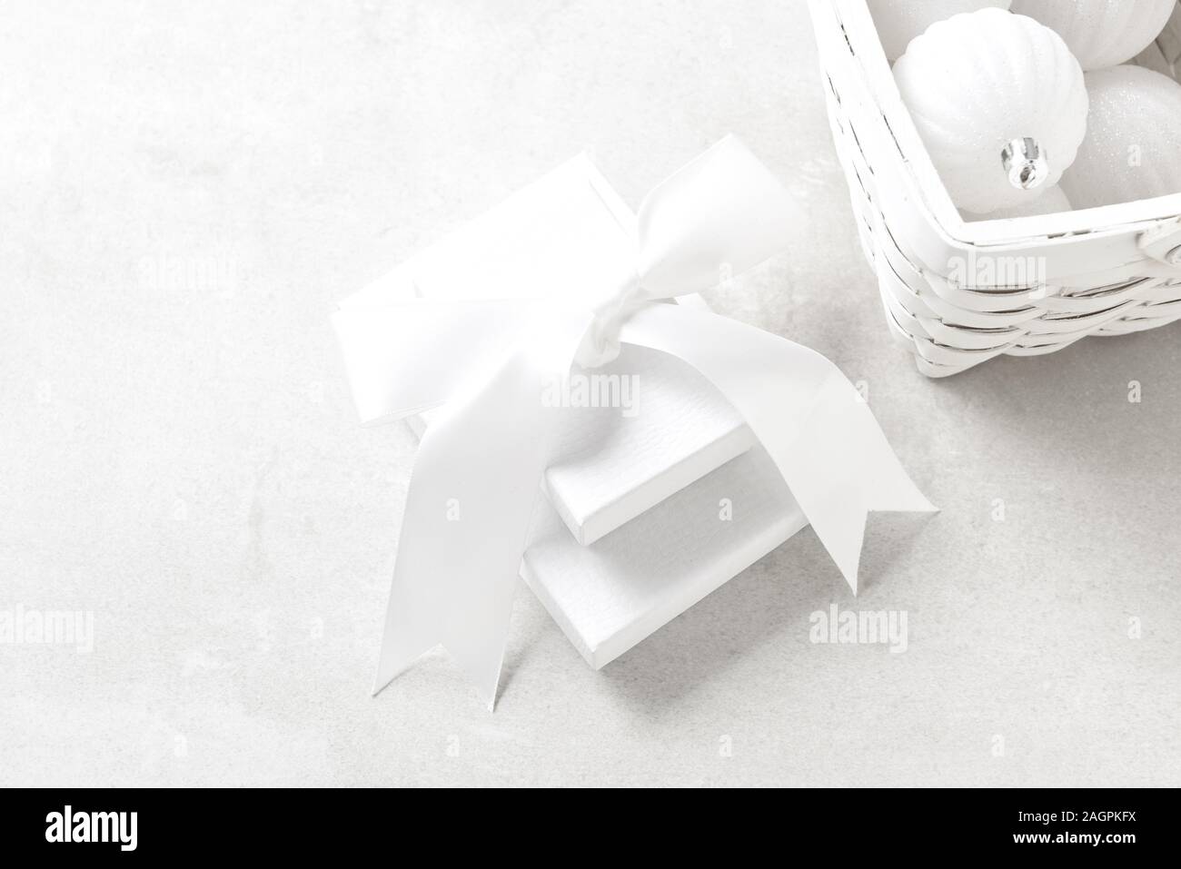 Bianco Natale ancora in vita con confezioni regalo e bow e un cesto di albero bianco ornamenti. Foto Stock Bianco Natale ancora in vita con confezioni regalo e bow e un cesto di albero bianco ornamenti. Foto Stock