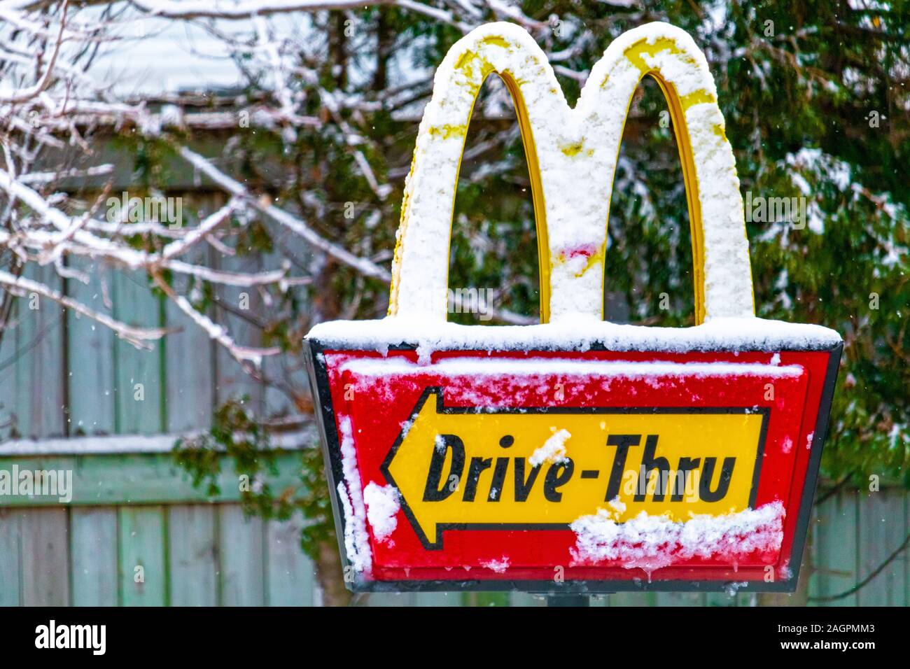 Il segno per un drive-thru a McDonald's ristorante fast food in Canada ha uno strato di neve su di esso dopo una tempesta di neve di vento. Foto Stock