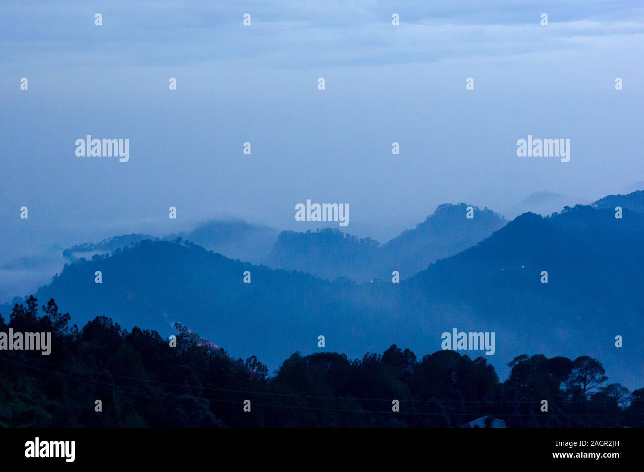 Crepuscolo colpo di colline coperte di nebbia e nuvole girato a McLeodganj dharamshala India Foto Stock