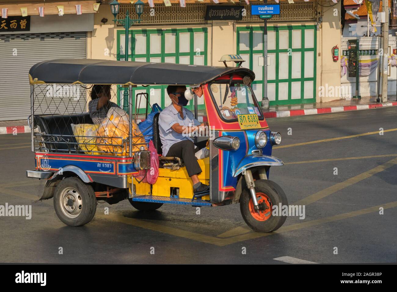 Un tuk-tuk (tre ruote di taxi) passando un tradizionale stile di bottega a Bangkok, in Thailandia Foto Stock