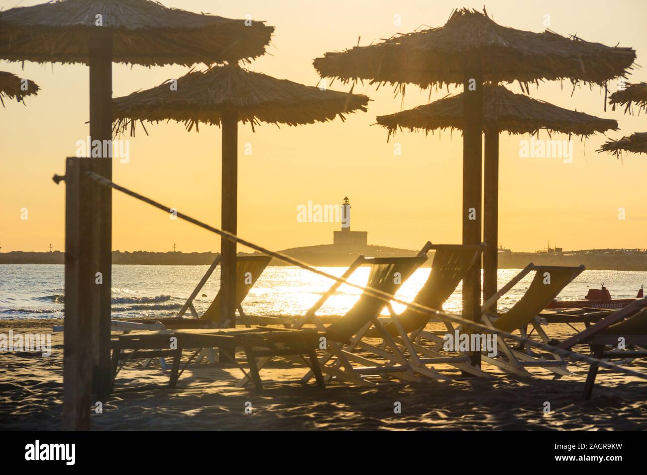 Tramonto sulla spiaggia con ombrelloni e lettini: Il Convento o la spiaggia di San Lorenzo si trova nelle vicinanze di Vieste in Puglia, Italia. Foto Stock