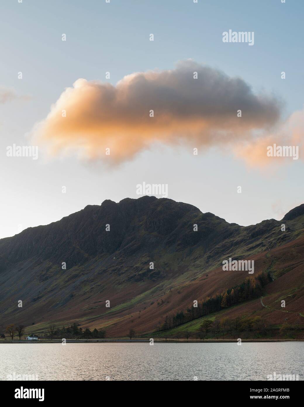 Incredibile epic Autumn Fall paesaggio Buttermere nel Lake District con una bella mattina presto la luce del sole giocando attraverso le colline e le montagne Foto Stock