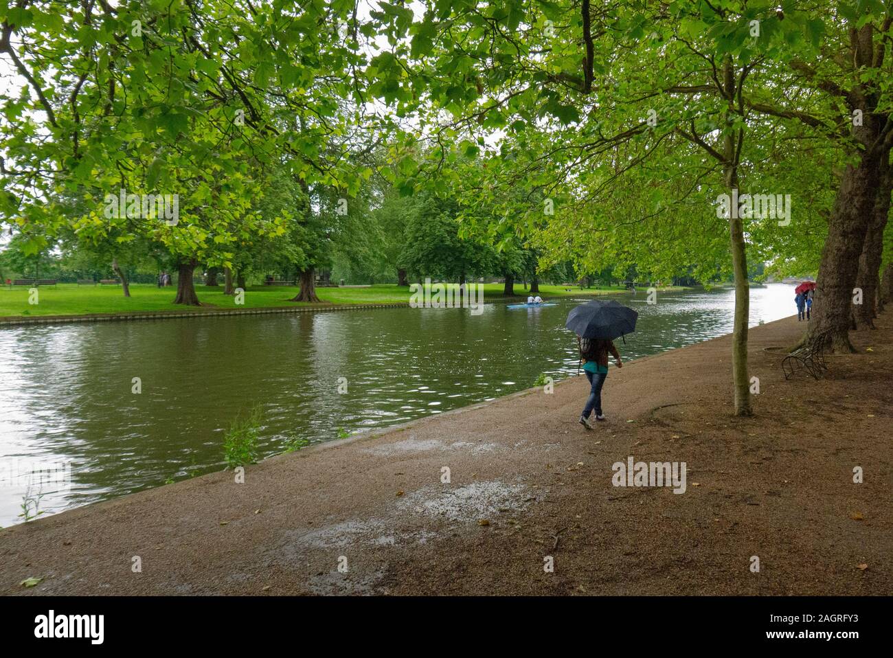 BEDFORD, Regno Unito - 21 Giugno 2012: Un pedestrain passeggiate sul bagnato estate giorno lungo gli argini del grande fiume Ouse in Bedford England Regno Unito Foto Stock