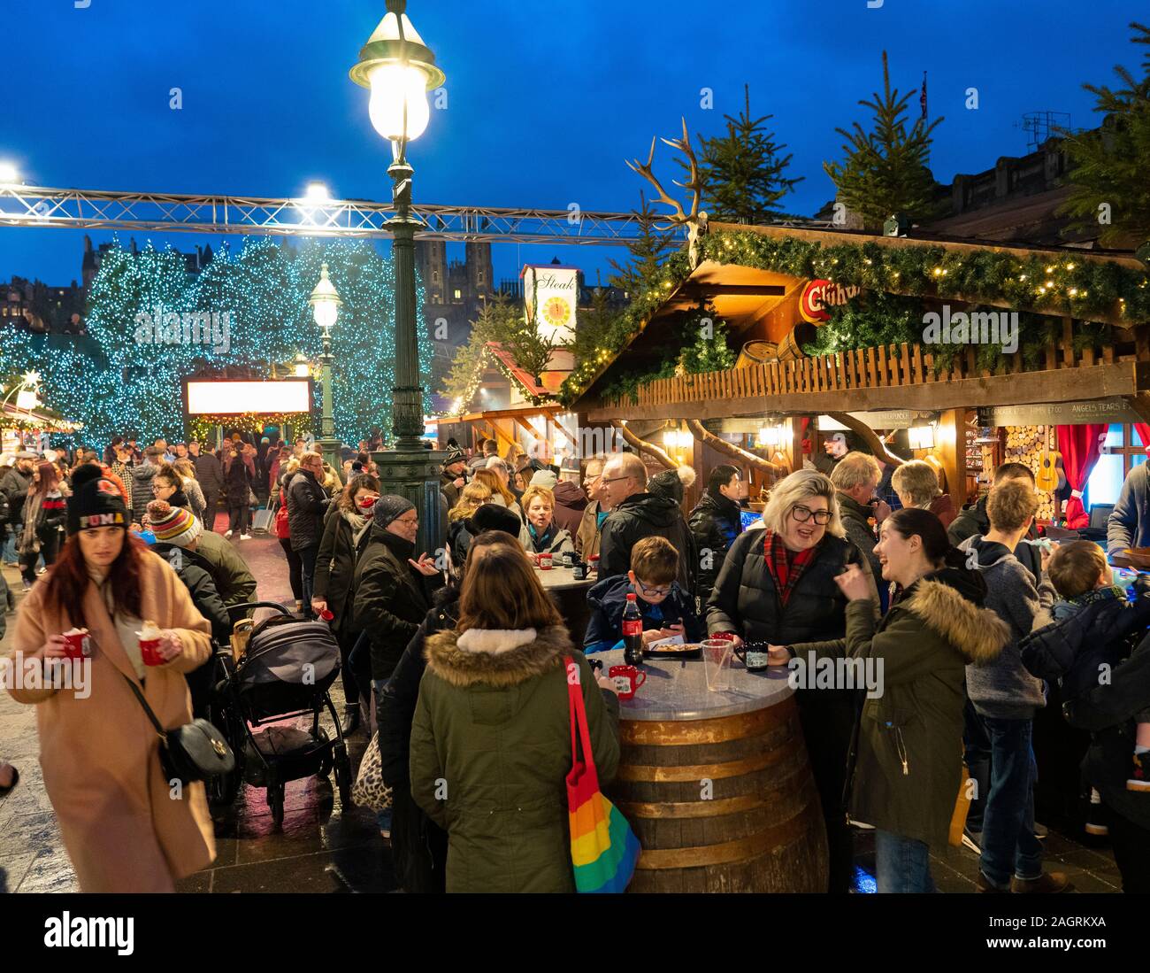 Vista di persone mangiare e bere a platea in busy Edinburgh Mercatino di Natale a ovest di Princes Street Gardens a Edimburgo, Scozia, Regno Unito Foto Stock