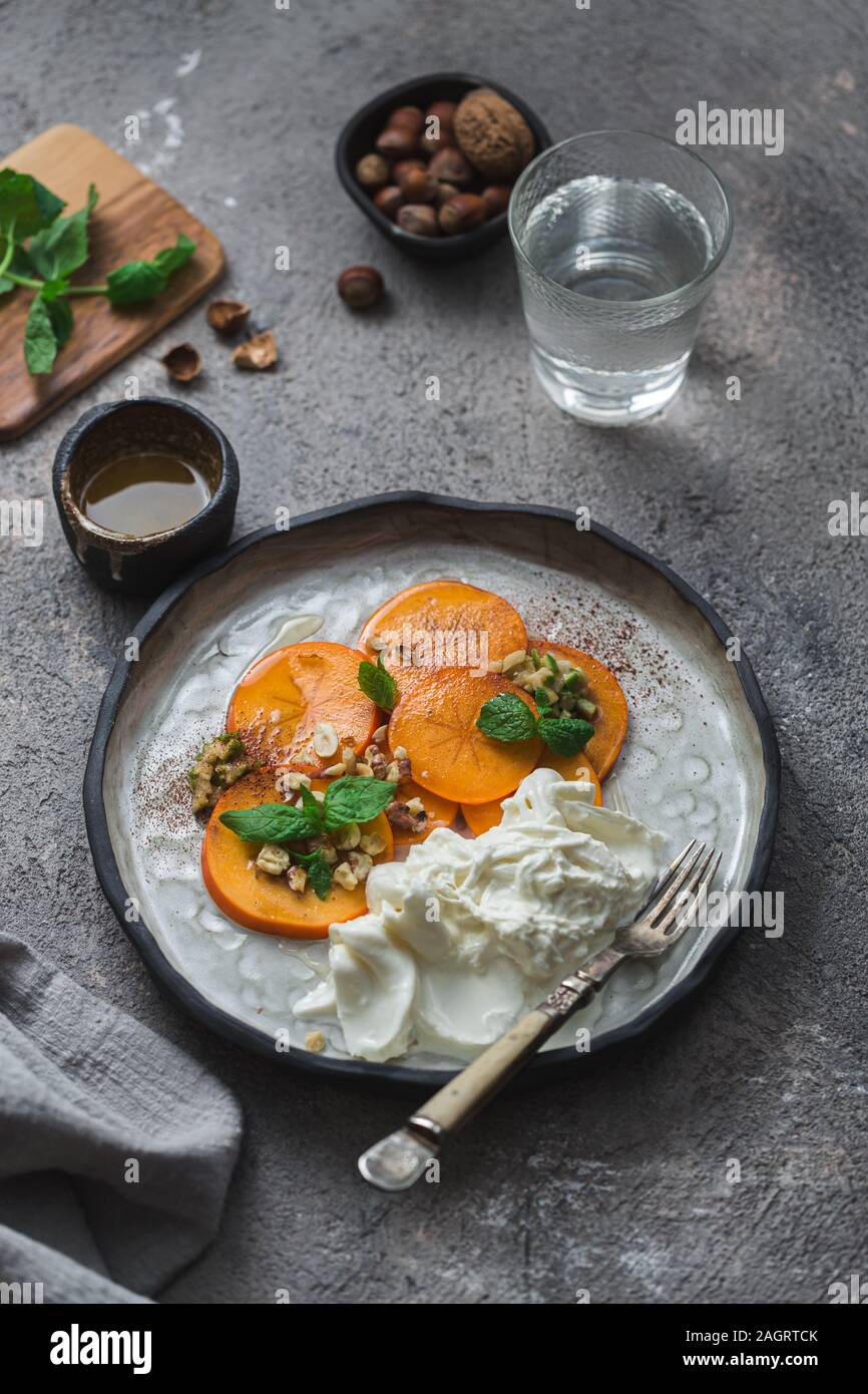 Buratta formaggio italiano con frutti serviti sulla piastra a mano Foto Stock