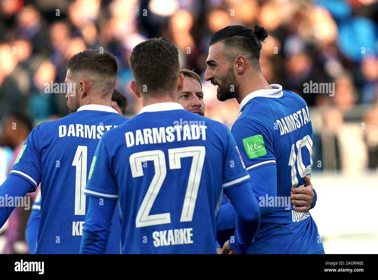 Darmstadt, Germania. Xxi Dec, 2019. Calcio: Seconda Bundesliga, Darmstadt 98 - Hamburger SV, XVIII Giornata. Darmstadt Serdar Dursun (r) è felice circa il suo obiettivo per il 1:1 con i suoi compagni di squadra Tim Skarke (M), Tobias Kempe (l) e Fabian Holland (indietro, undercover). Credito: Hasan Bratic/dpa - NOTA IMPORTANTE: In conformità con i regolamenti del DFL Deutsche Fußball Liga e la DFB Deutscher Fußball-Bund, è vietato sfruttare o hanno sfruttato nello stadio e/o dal gioco fotografie scattate in forma di sequenza di immagini e/o video-come la serie di foto./dpa/Alamy Live News Foto Stock