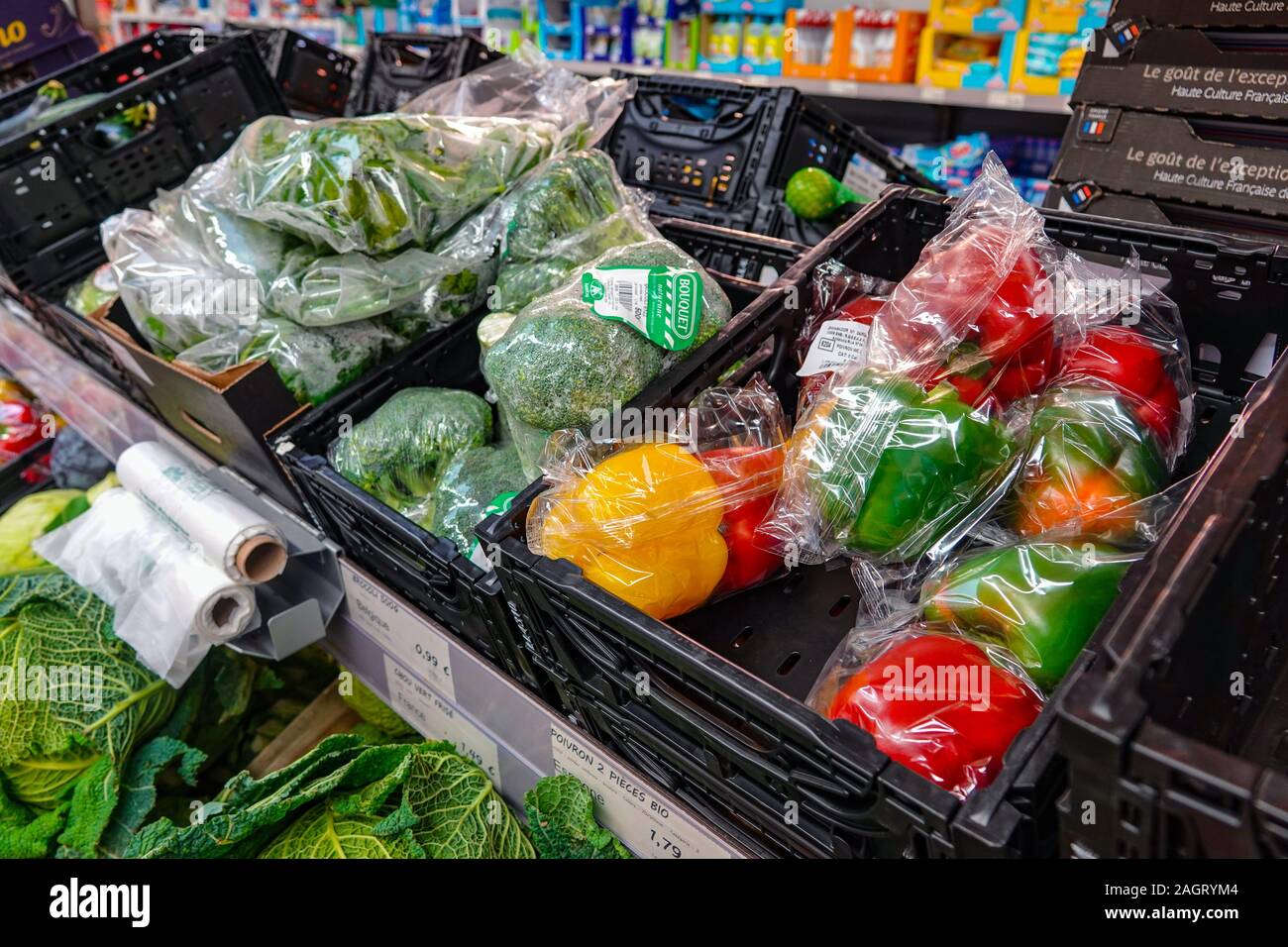 Uso singolo avvolgimento di plastica intorno a verdure colorate nel supermercato Aldi Foto Stock