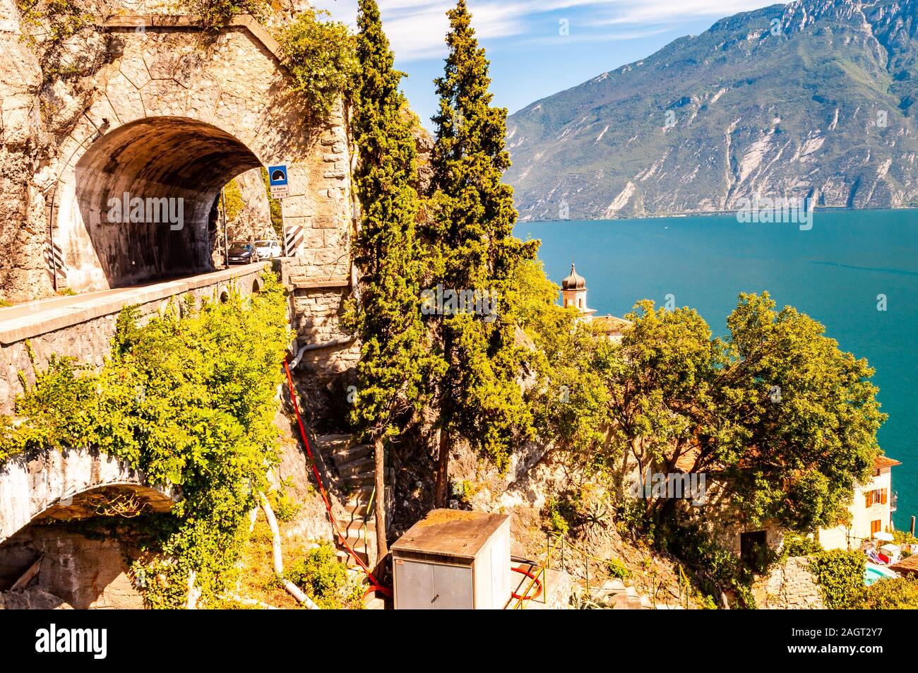 Scenic strada panoramica intorno al lago di Garda piena di tunnel e gallerie realizzate nelle rocce in corrispondenza del bordo di una linea costiera Foto Stock