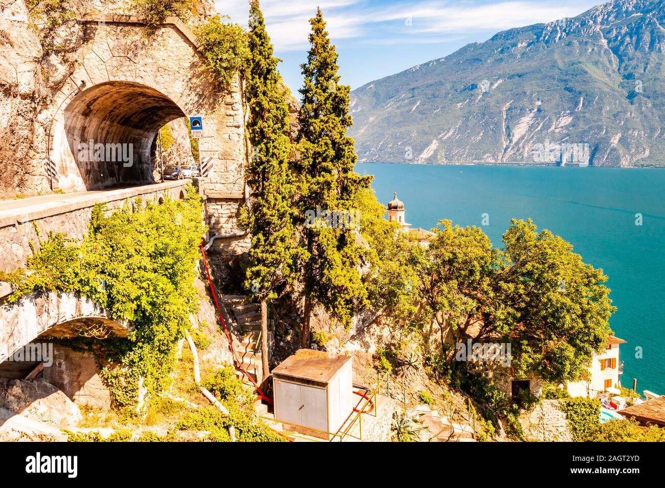 Scenic strada panoramica intorno al lago di Garda piena di tunnel e gallerie realizzate nelle rocce in corrispondenza del bordo di una linea costiera Foto Stock