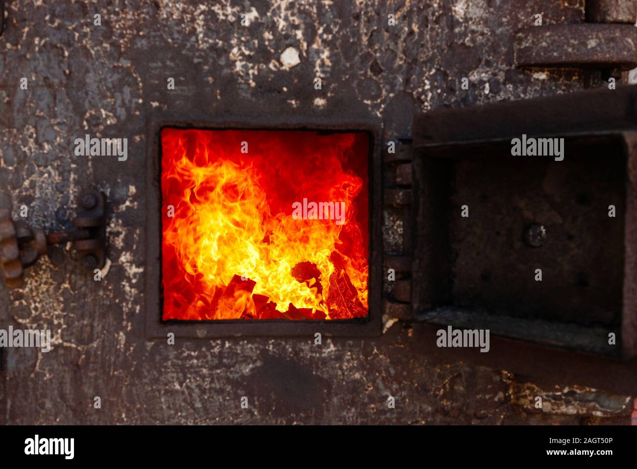 Aprire lo sportello con il fuoco in un vecchio tailandese tradizionale crematorio. Foto Stock