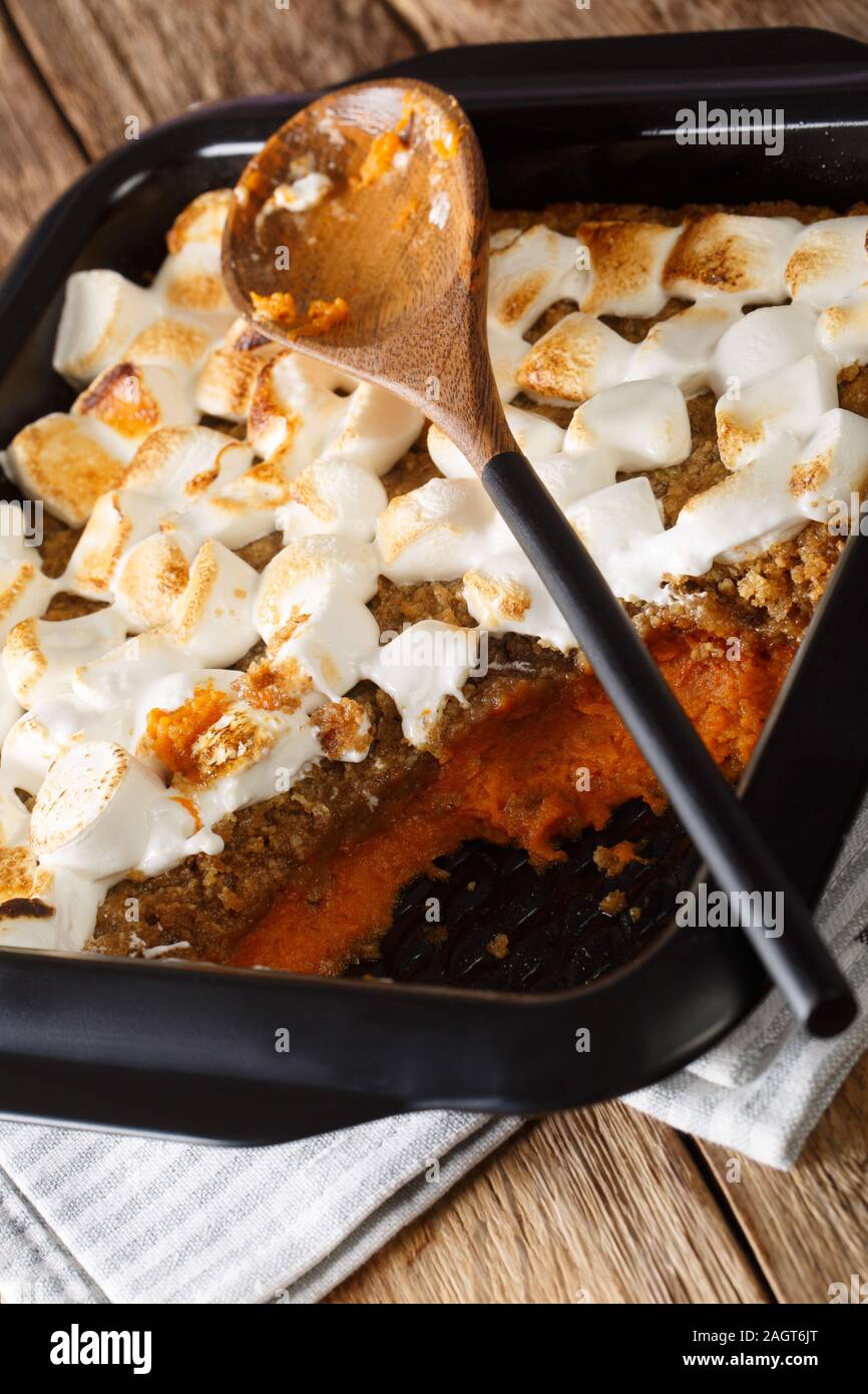 American patata dolce casseruola con le noci pecan e marshmallows close-up in una teglia sul piano verticale. Foto Stock