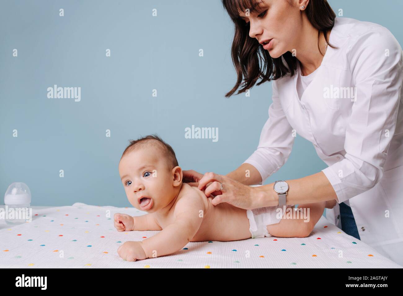 Donna pediatra facendo massaggi a baby boy Foto Stock