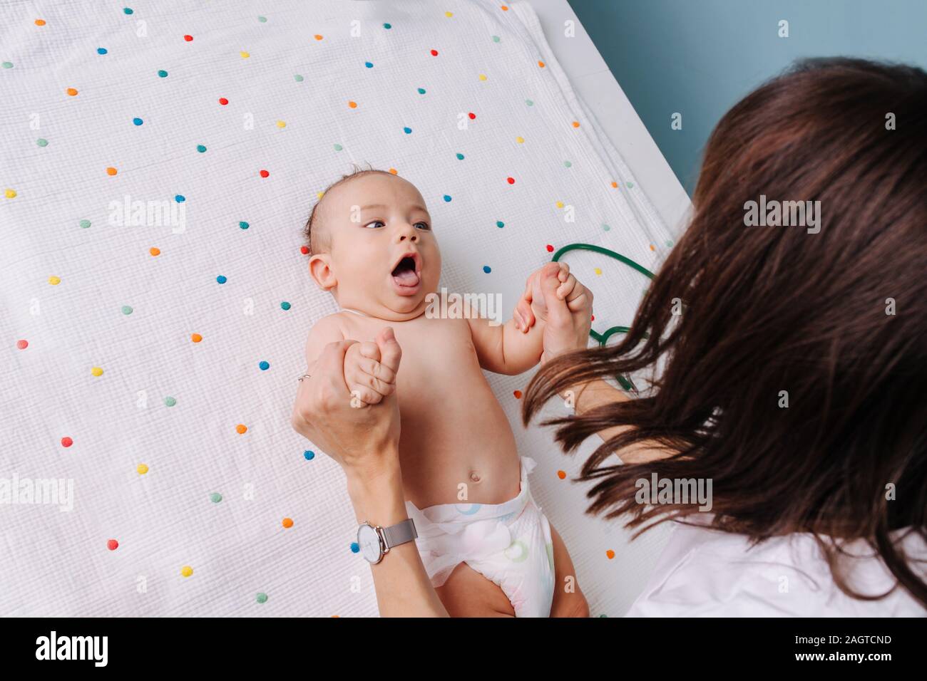 Medico pediatra controlla il bambino di riflessi di presa Foto Stock