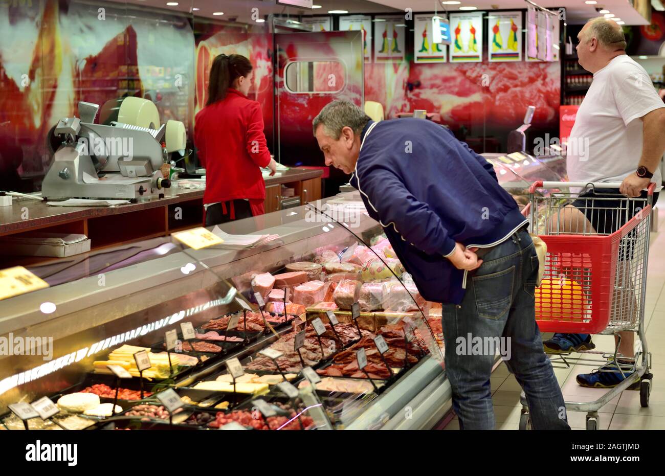 Supermercato contatore di carne con un uomo guarda la selezione nel supermercato Plodine, Balla, Croazia, Foto Stock