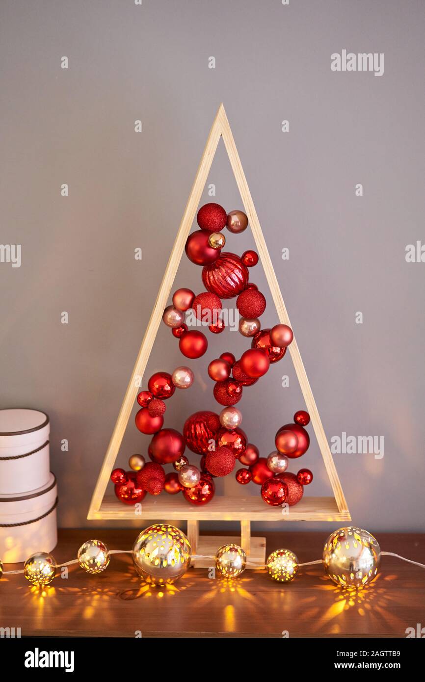 Legno Alternative albero di natale. Un artigianale di albero di Natale e di rosso le palle di Natale. Foto Stock
