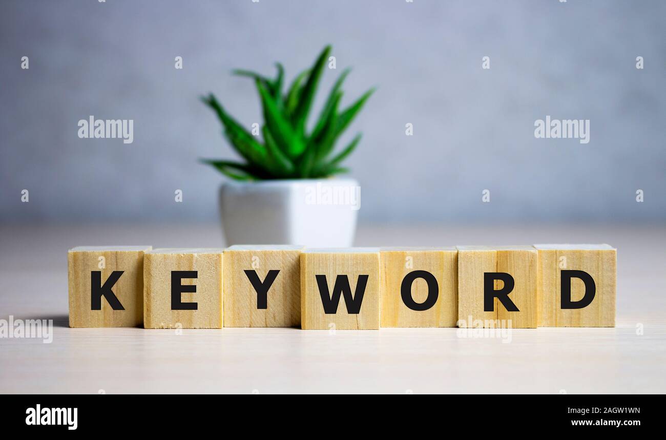 Parola chiave - parola da blocchi di legno con lettere, le informazioni di ricerca che contiene la parola chiave parola concetto, sfondo blu. Foto Stock