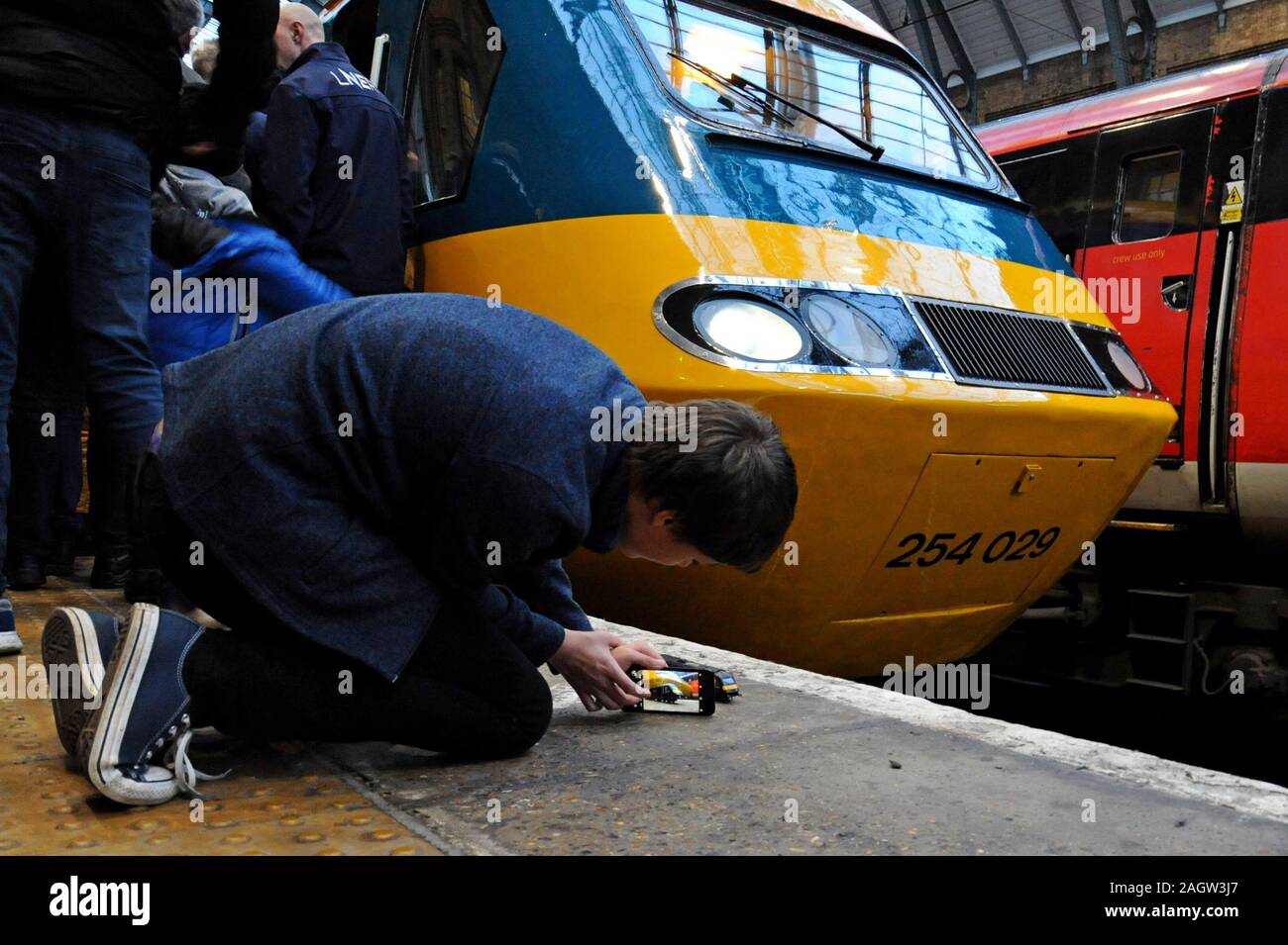 Stazione di King Cross, Londra, Regno Unito. Il 21 dicembre 2019. Londra nord-orientale della società ferroviaria restaurato un InterCity 125 insieme al suo originale British Rail livrea per una speciale della durata di quattro giorni in giro per la rete LNER come i treni fine 40 anni di servizio sulla East Coast Main Line. Un appassionato di giovani fotografie del suo modello HST di fronte la cosa reale. G.P. Essex/Alamy Live News Foto Stock