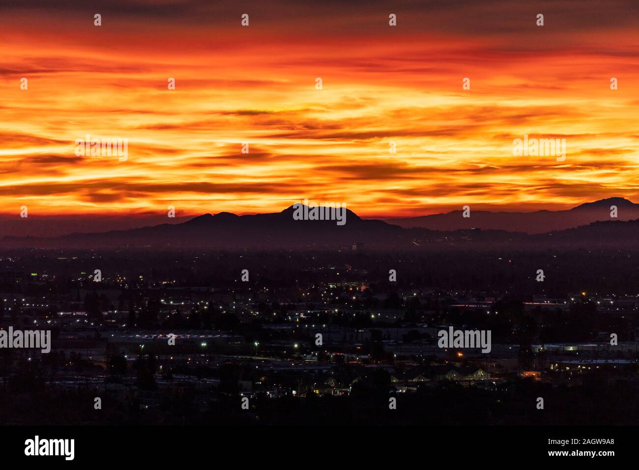 Fiery predawn vista su tutta la valle di San Fernando verso Griffith Park della città di Los Angeles, California. Foto Stock
