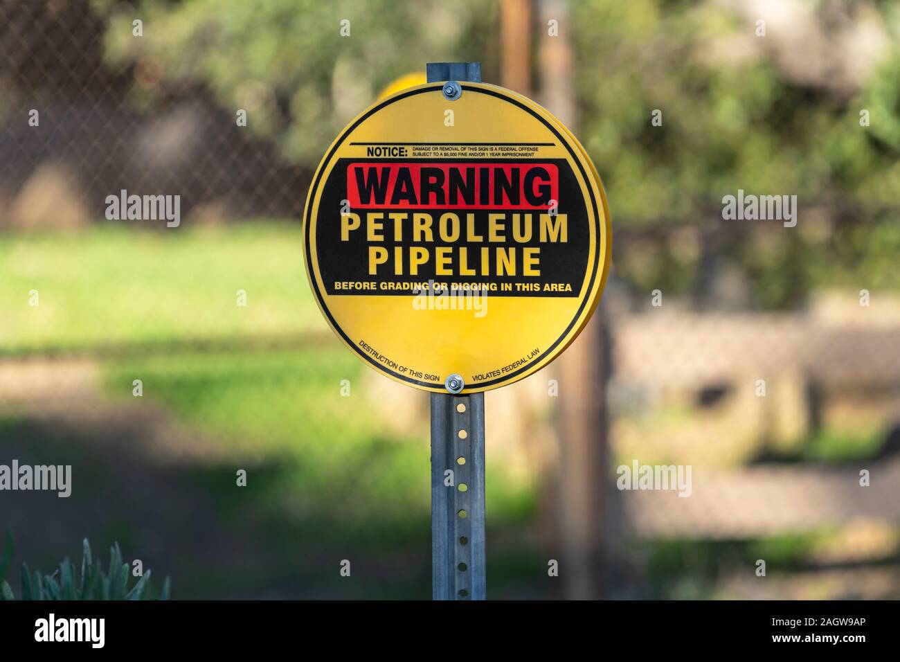 Pipeline di petrolio cartello segnaletico con catena collegamento recinto e in background. Foto Stock