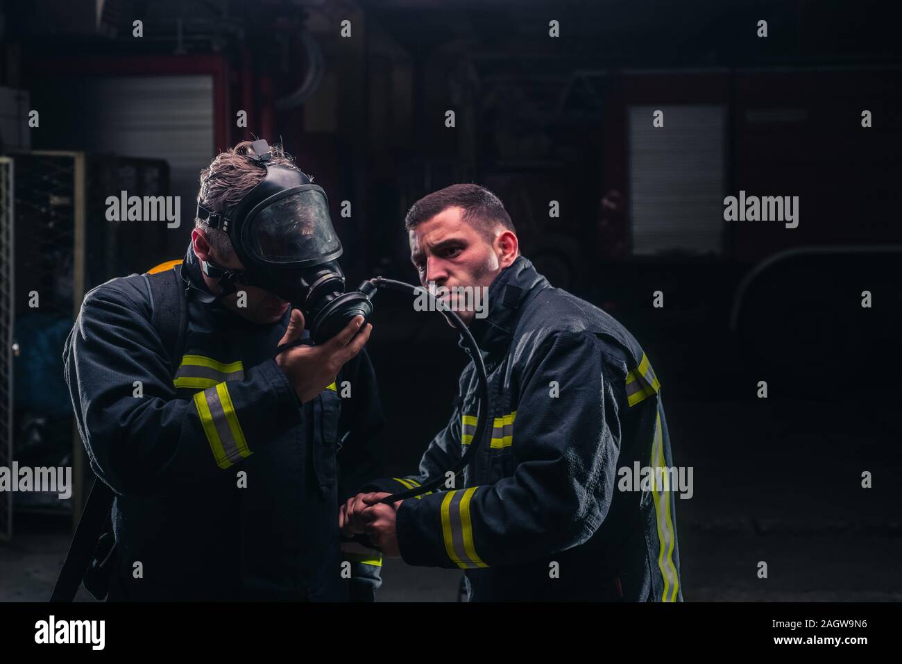 I vigili del fuoco con uniforme protettivo indossando maschere di ossigeno Foto Stock