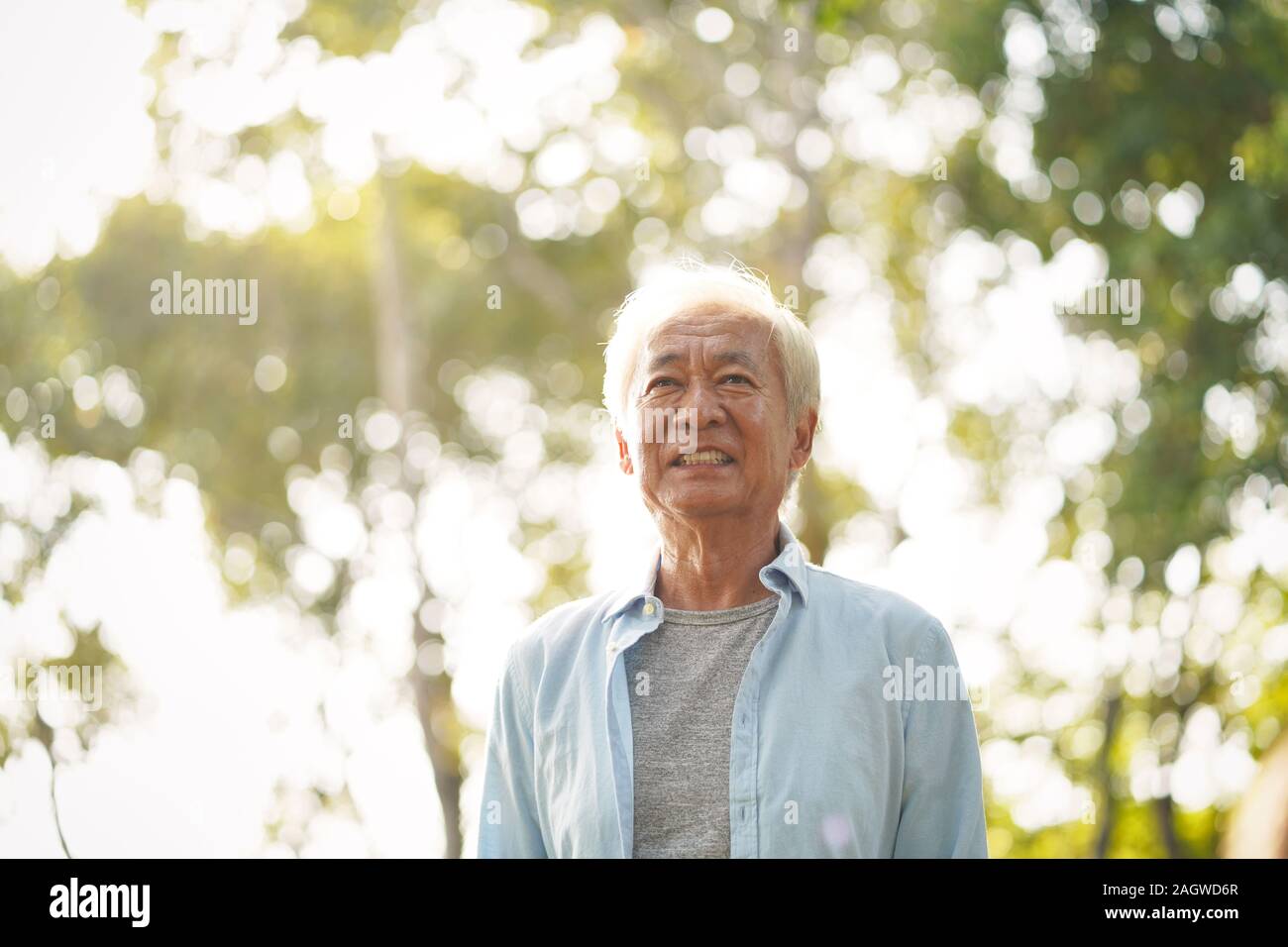 Ritratto outdoor cinese di vecchio uomo, felice e sorridente Foto Stock