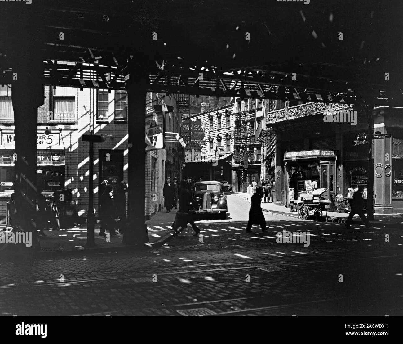 Esaminando Deyer San da sotto la ferrovia sopraelevata; segni per le imprese cinesi; ristoranti su angoli; venditore ambulante. Foto Stock