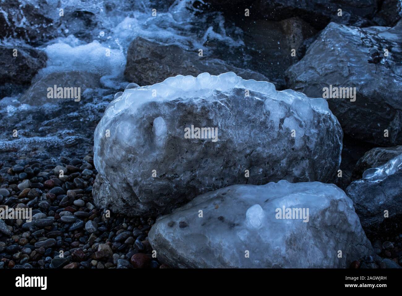 Primo piano delle rocce ghiacciate sul lago Ontario in una giornata invernale Foto Stock