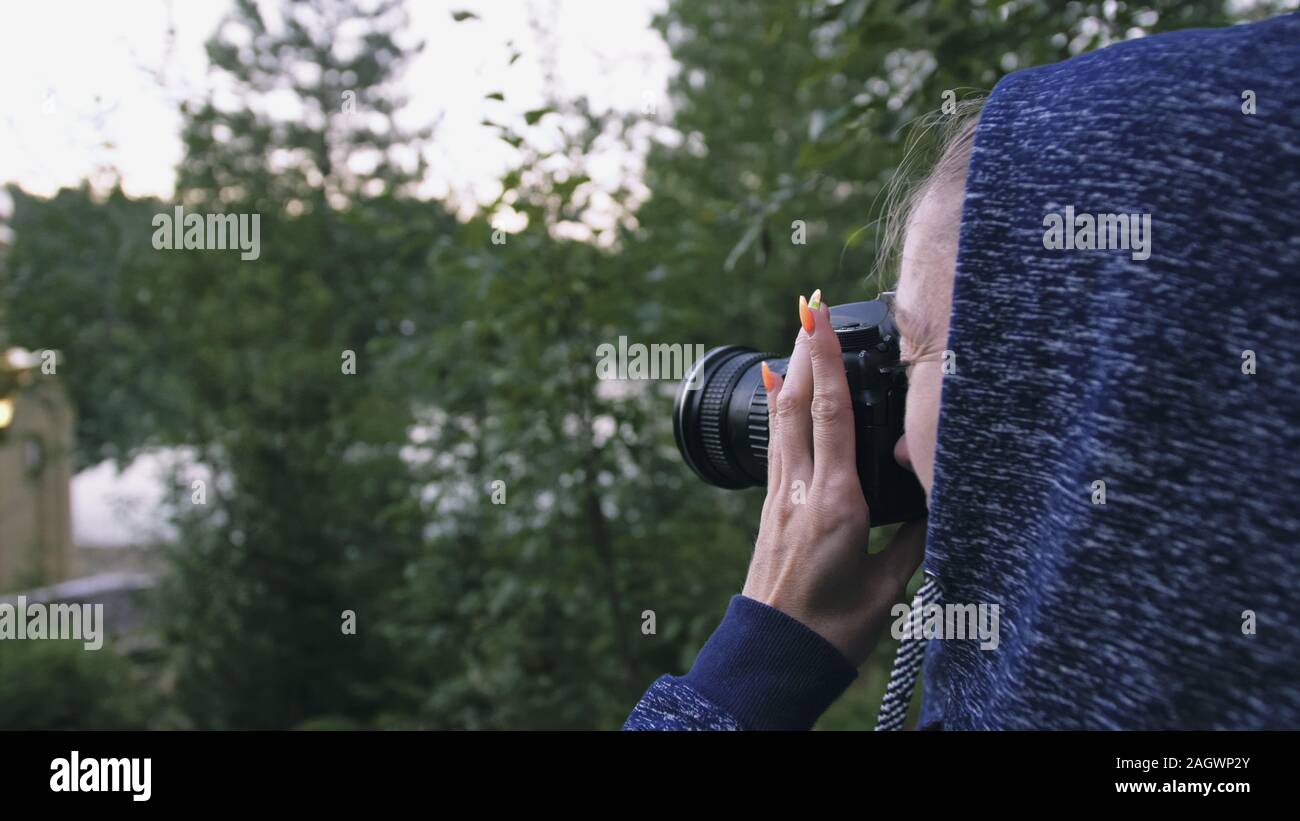 Traveler fotografare la vista panoramica nella foresta. Una donna caucasica bello scatto magic look. Ragazza scatta foto video su mirrorless reflex fotocamera. Foto Stock