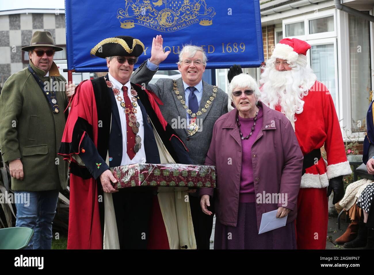 Chichester, Regno Unito. Xxi Dec, 2019. Strano evento inglese dove i membri della carriola Club di Chichester donare pacchi alimentari per gli anziani e poi ruota il sindaco di ritorno nel centro città in una carriola. Questo è il 123carriola esegui. La carriola Club di Chichester si riferisce all'antica Corporation di St Pancras fondata nel 1689 per celebrare Guglielmo d Orange accedere al trono. È la più lunga istituito dining club nel Regno Unito. Nella foto è azione dallo storico evento che si svolgerà. Credito: Sam Stephenson/Alamy Live News Foto Stock