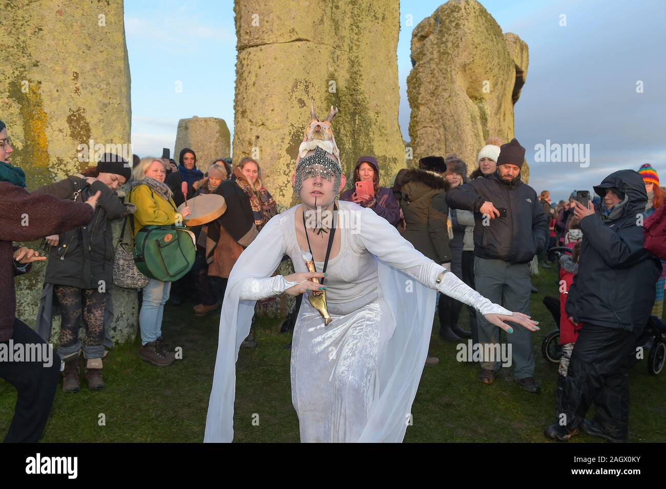 Wiltshire, Regno Unito. 22 Dic, 2019. Festaioli a Stonehenge benvenuti l'alba del solstizio d'inverno il giorno più corto dell'anno. Il sole è salito a 08;04am ufficiale e la Solstice nell emisfero nord era a 04.19am domenica 22 dicembre 2019. Pagan festeggiare più lunghe ore di buio e il ritorno del sole come giorni di ottenere più fino a quando il solstizio d'estate. Credito: MARTIN DALTON/Alamy Live News Foto Stock