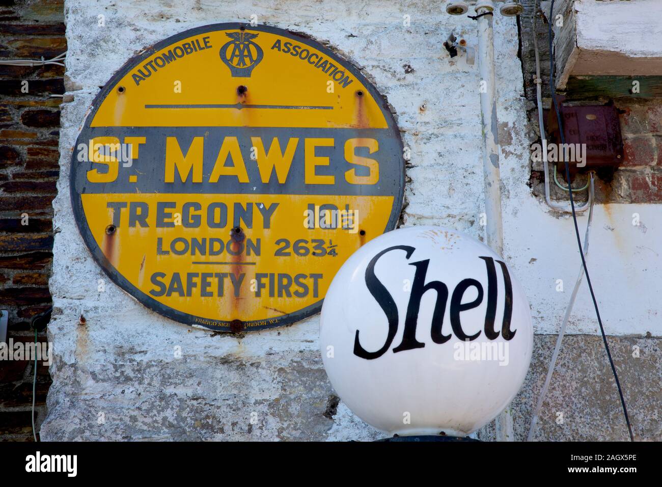 Classica pompa a benzina Shell in vecchio stile e segno smaltato AA a St Mawes, Cornwall, Regno Unito Foto Stock