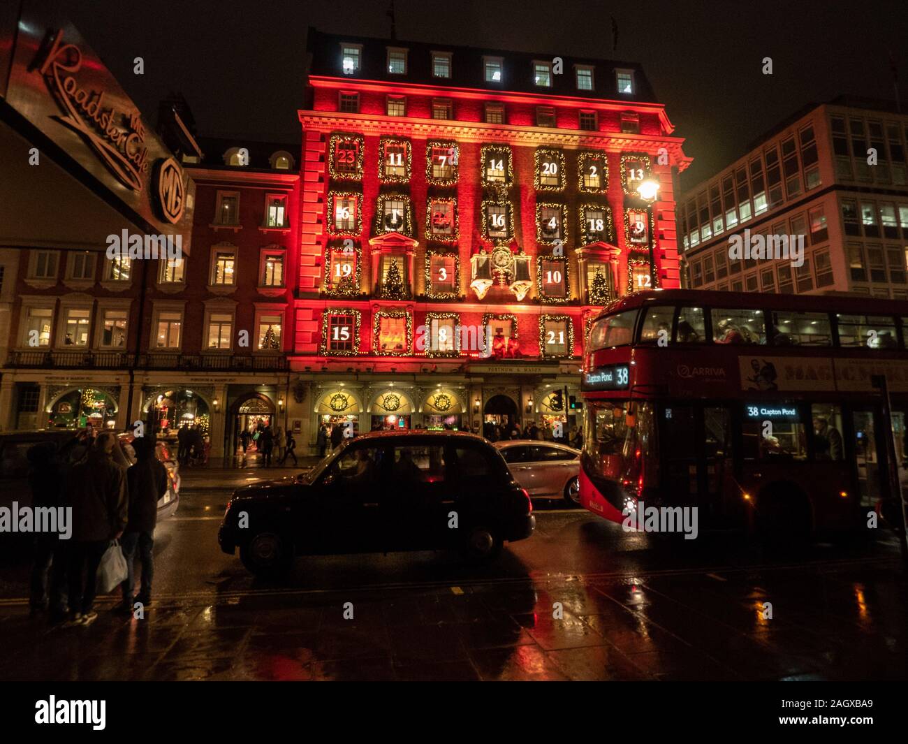 La facciata rossa del "Calendario dell'Avvento" del grande magazzino Fortnum & Mason a Piccadilly, Londra Foto Stock