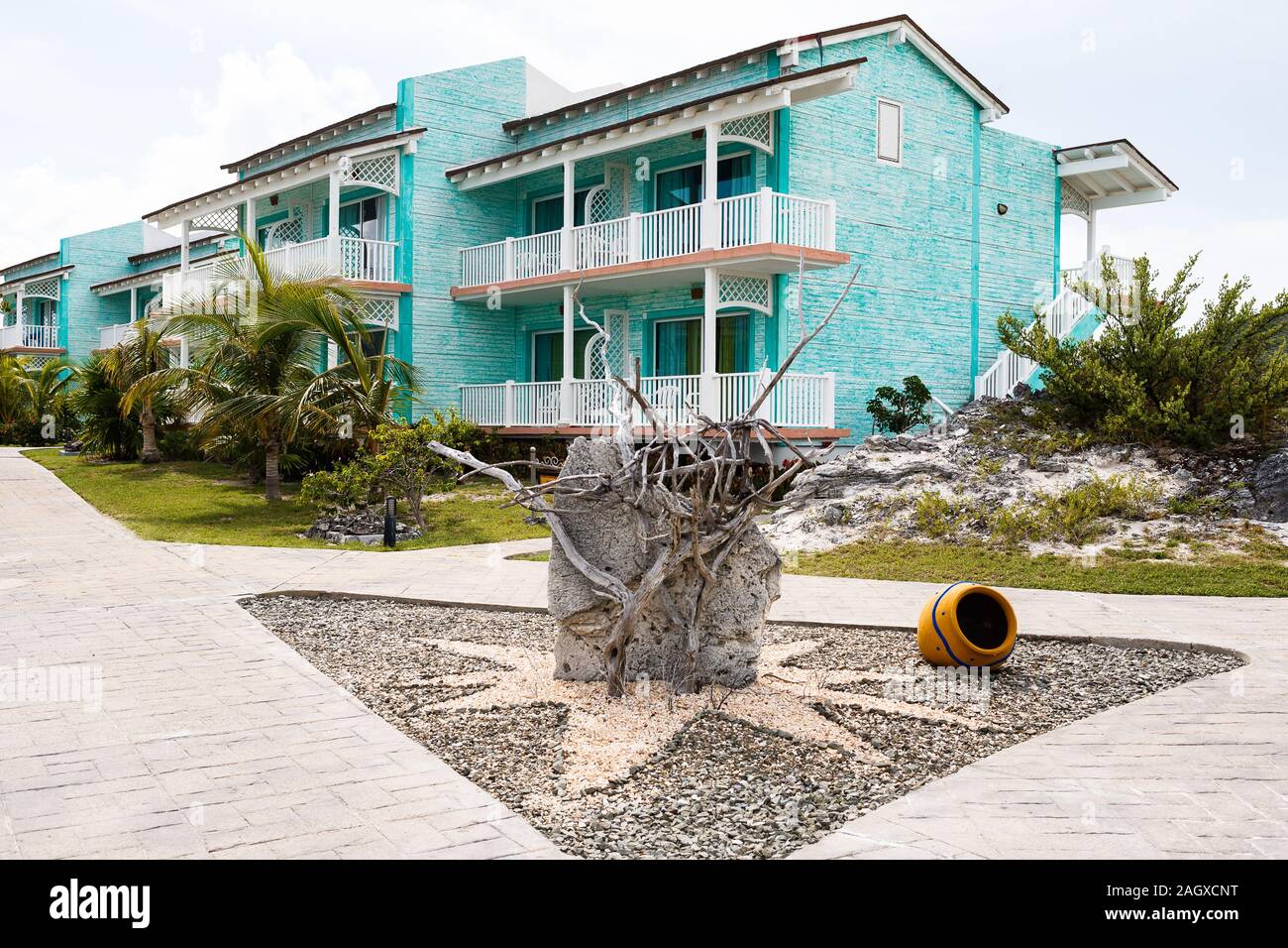 Decorazione giardino in pietra, rami morti di fronte a casa a due piani Foto Stock