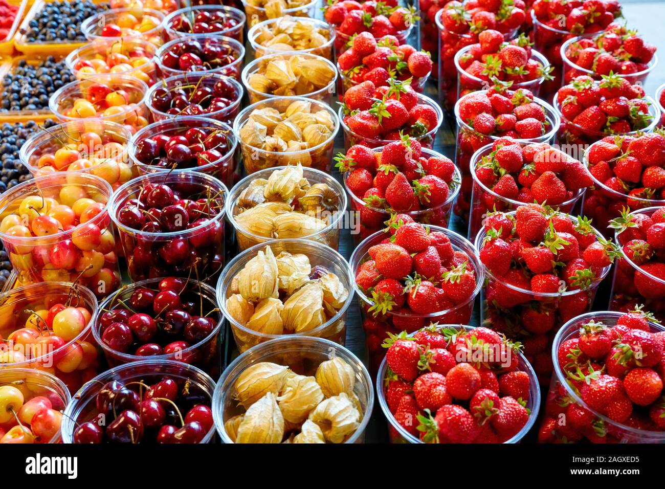 Rasbhari lampone, fragola, Ciliege in contenitori di plastica. Frutta fresca al display sul mercato degli agricoltori in stallo. Foto Stock