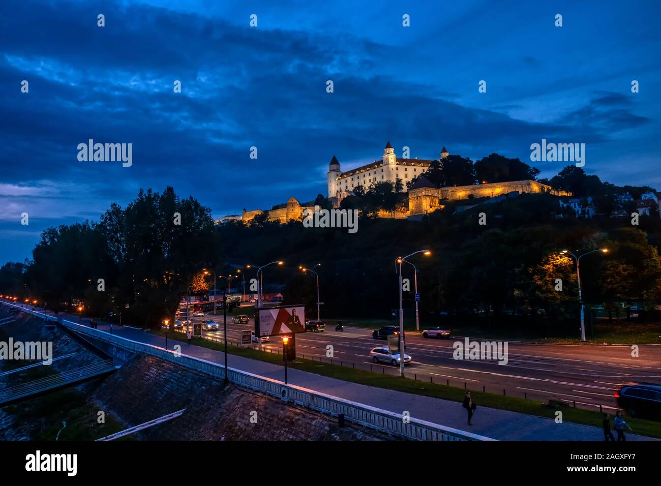 Bratislava, Slovacchia - 24 Settembre 2019: il castello di Bratislava illuminato nel bagliore di sera contro il cielo drammatico, moody e la romantica scena di pietra miliare nella Foto Stock