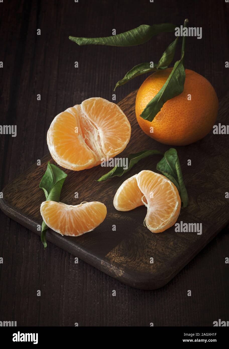 I mandarini satsuma ,facile peelers su scuro dello sfondo in legno Foto Stock