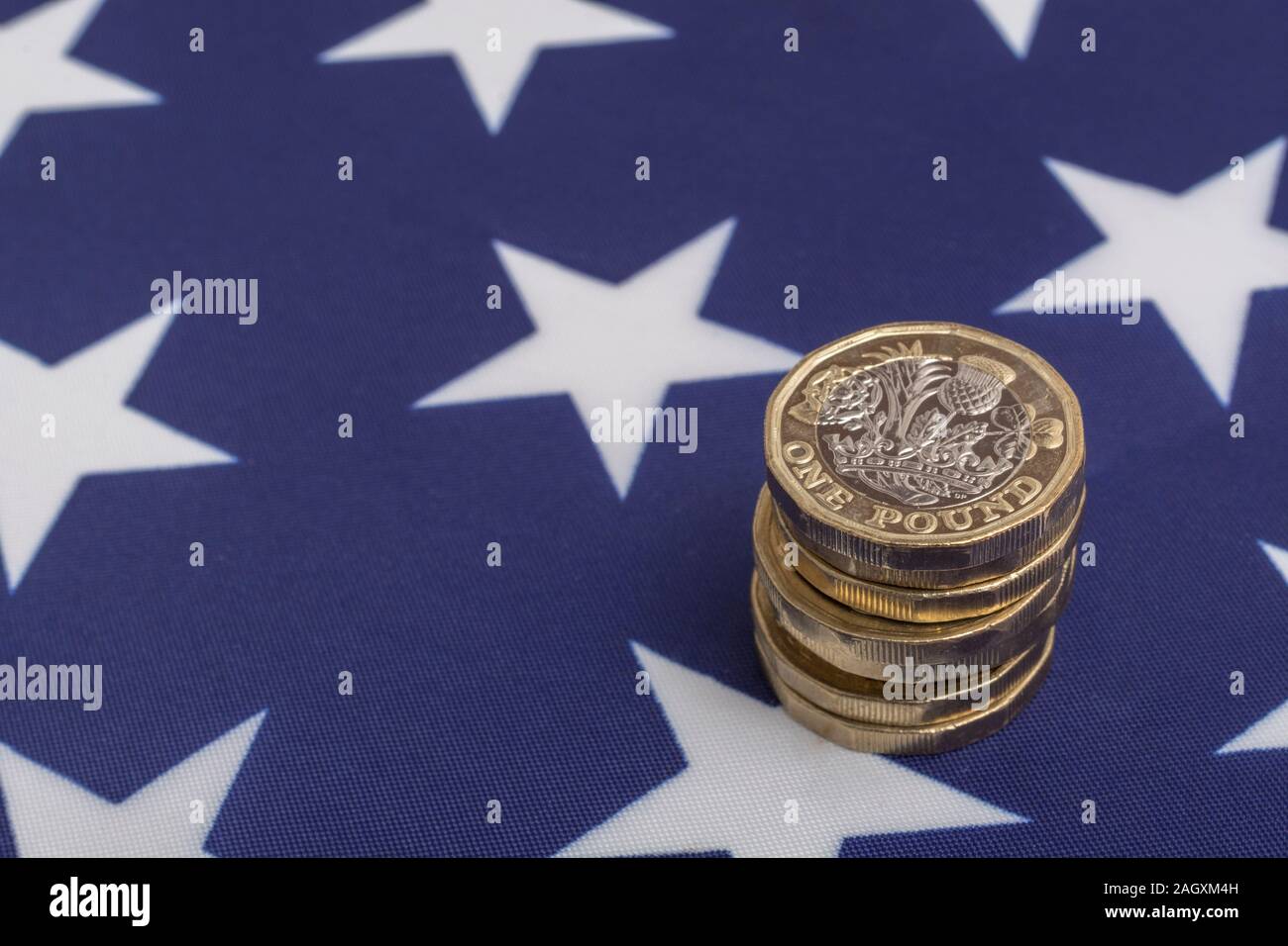 Impilati £1 monete su American Stars & Stripes flag. Metafora US-UK Trade deal post Brexit, Sterline etasso di cambio, il valore in dollari della sterlina, esportazioni britanniche di noi Foto Stock