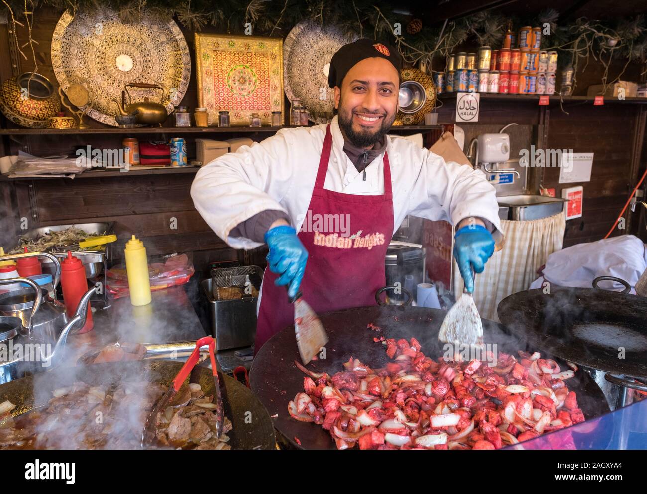 Uno chef cucinare il pollo Tikka alla Edinburgh mercatino di Natale, Edimburgo. Foto Stock