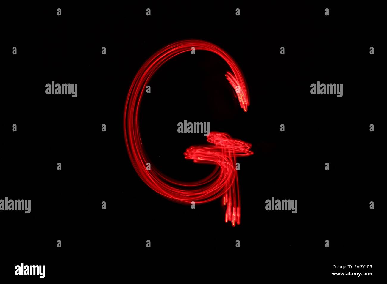 La pittura di luce fotografia di alfabeto lettere, disegnato da luci fairy in neon di colore rosso su sfondo nero. Fotografie con lunghi tempi di esposizione. Foto Stock