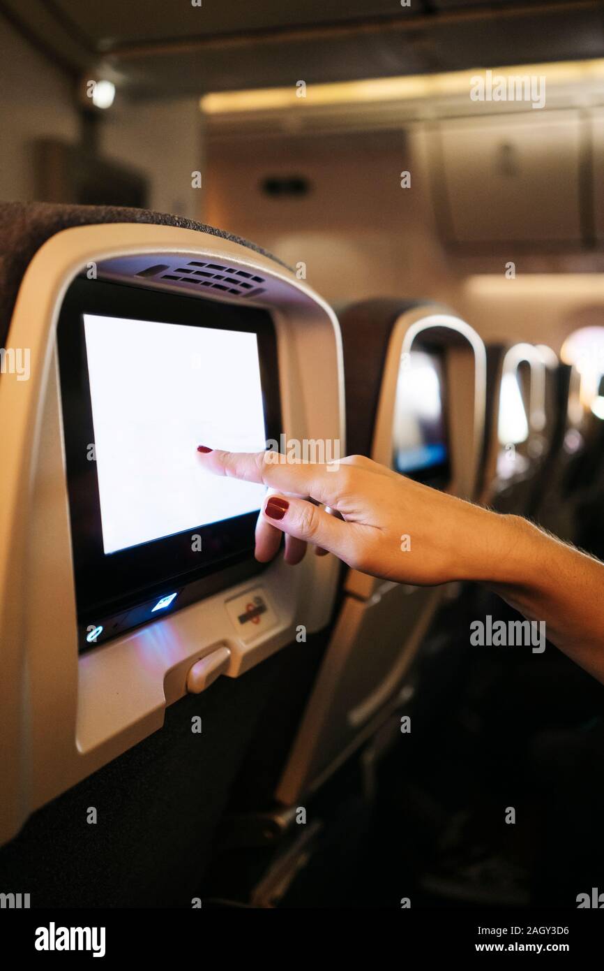 Dettaglio di una donna con le mani in mano utilizzando il touch screen di un aereo Foto Stock