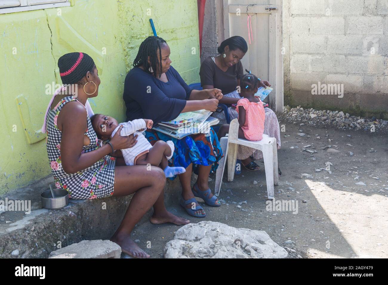 Immagine drammatica di affrettare le donne e un bambino di godere di un programma di istruzione in un piccolo paese di montagna in Repubblica dominicana. Foto Stock
