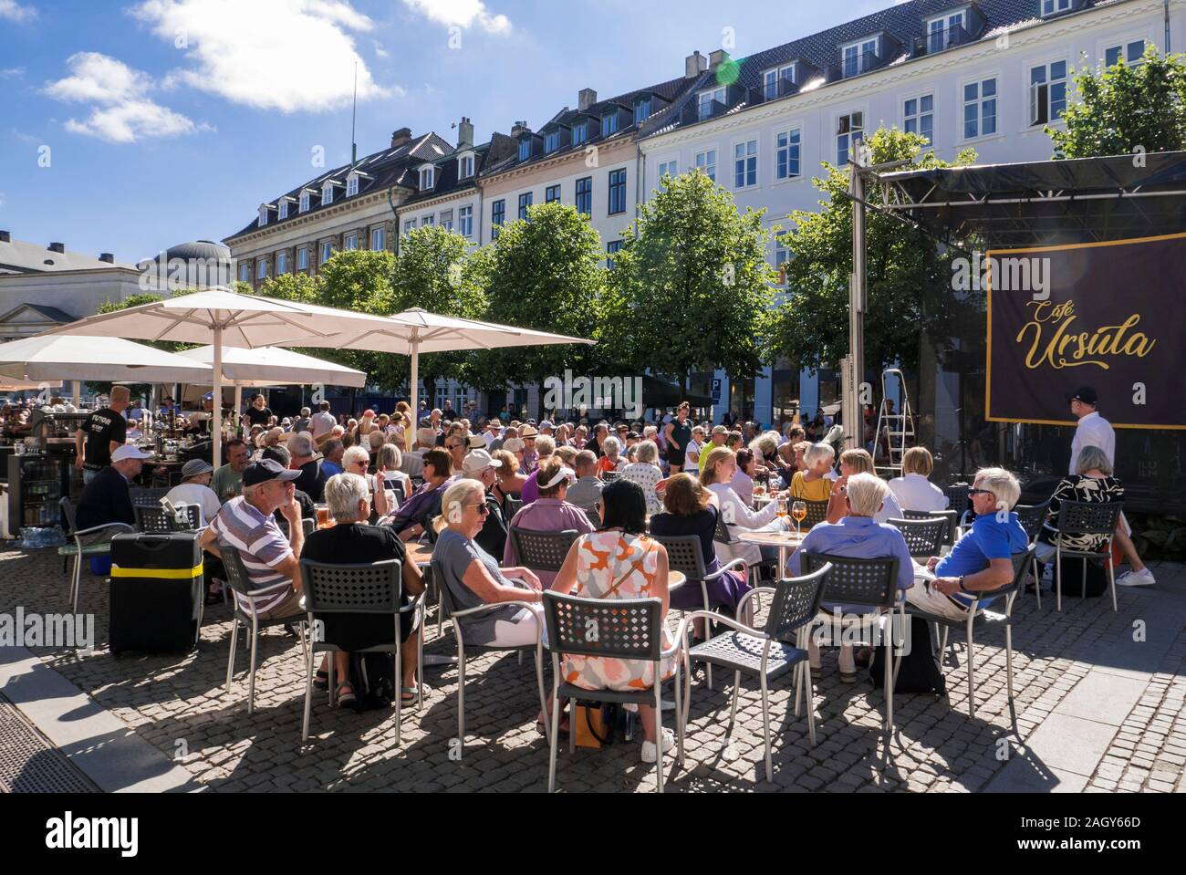 La gente seduta in sun ascoltando musica dal vivo a Copenhagen, Danimarca Foto Stock